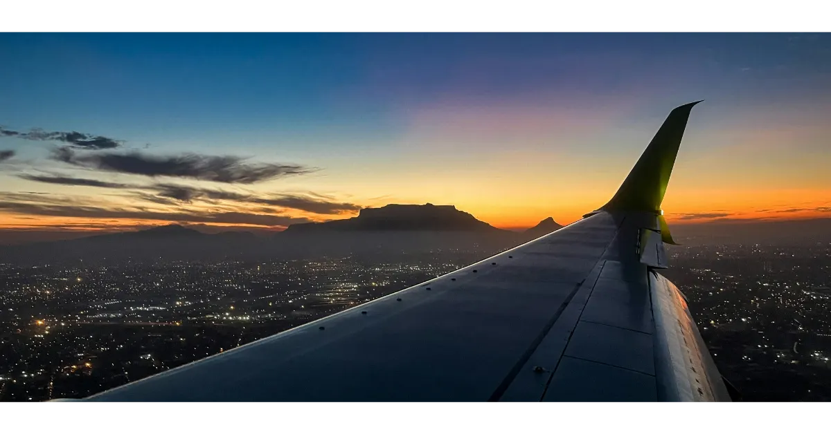 View from an airplane window during a long-haul business class flight to Africa at sunset